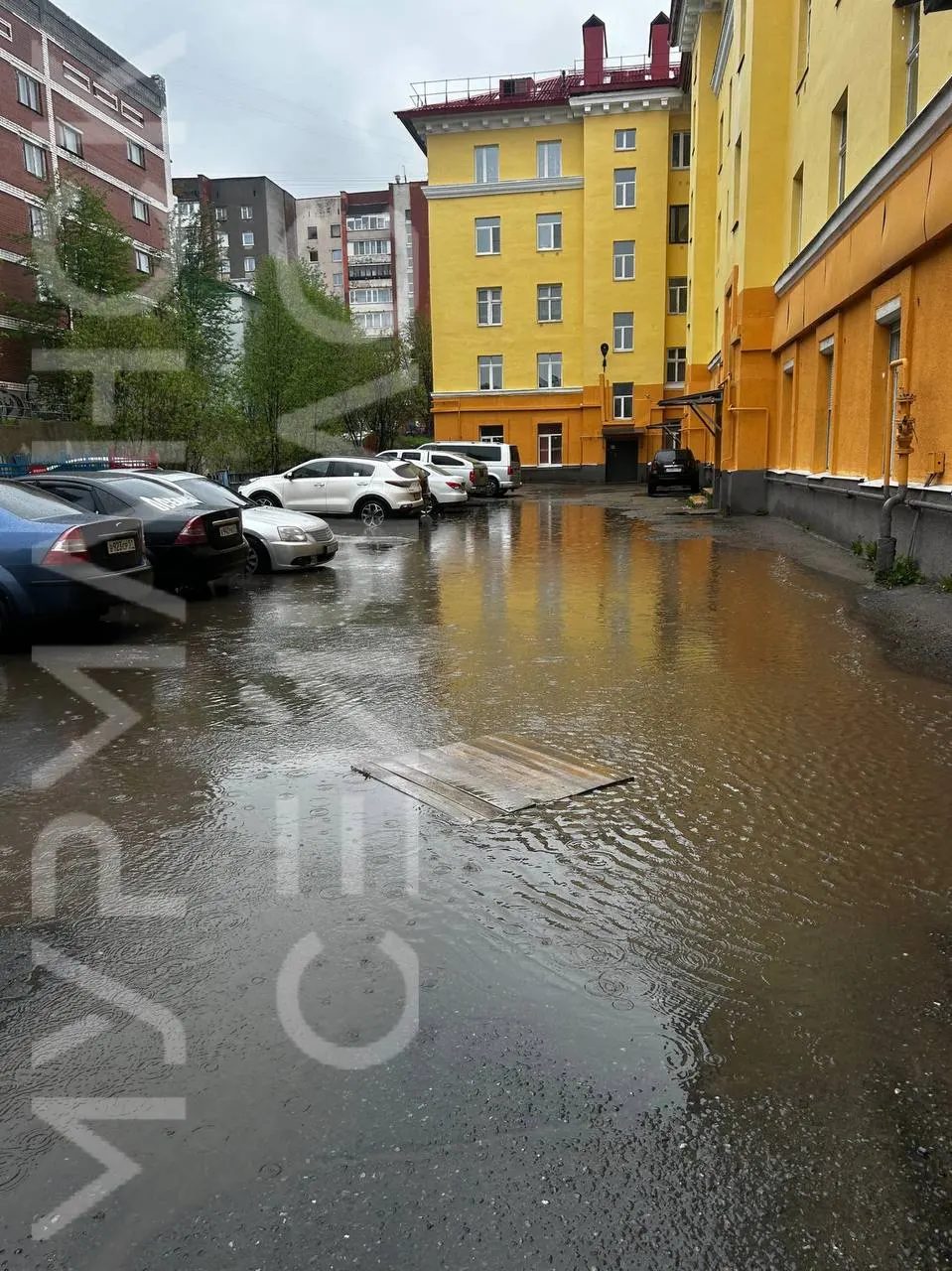 Из‑за продолжительных осадков, отсутствия ливнёвок и неровного асфальта во дворе дома на улице Шмидта, 17 скопилось большое количество воды — жители не могут пройти без резиновых сапог.